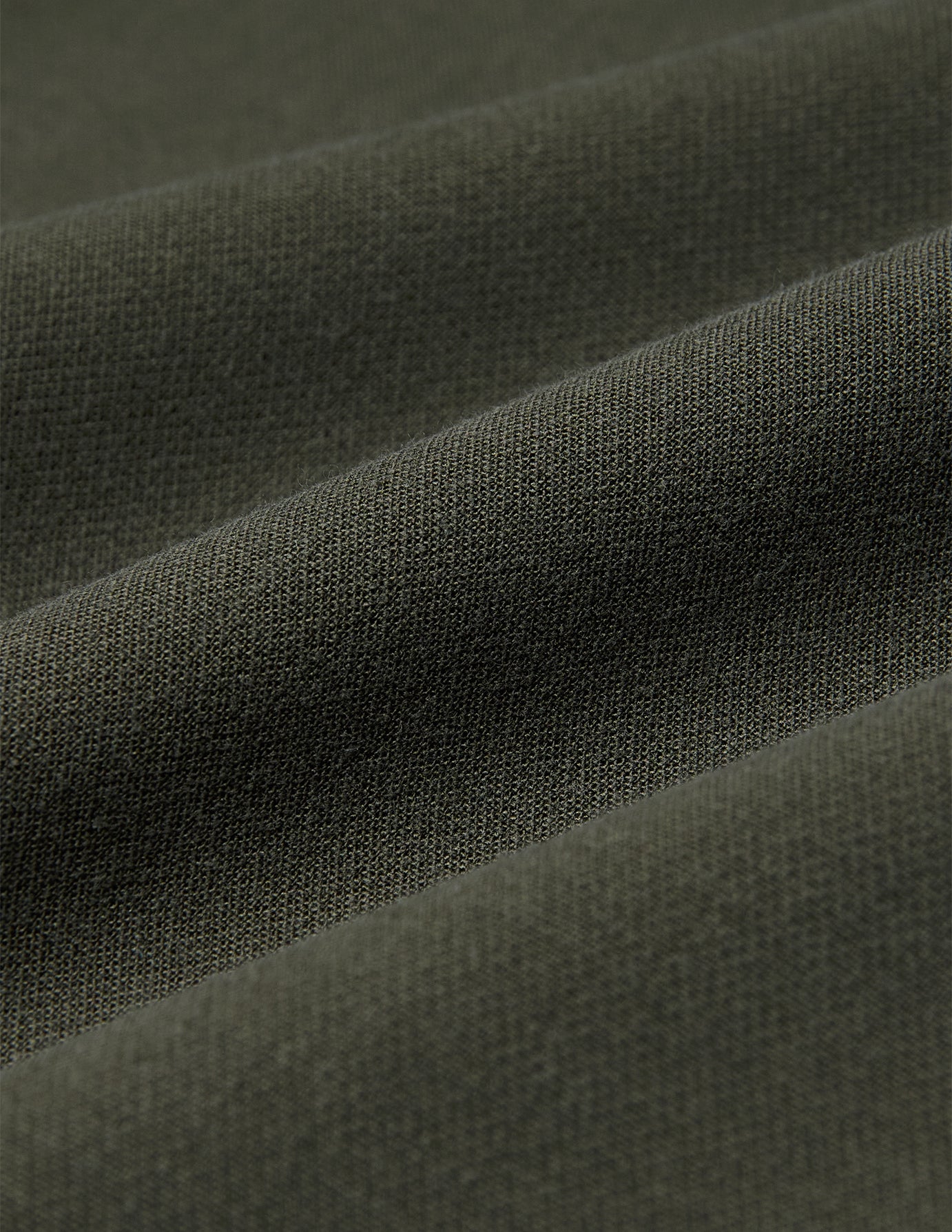 Nahaufnahme der Women GO2 Pants Straight Dusty Olive aus olivgrünem Doubleface-Stoff mit den für skandinavisches Design charakteristischen diagonalen Falten.